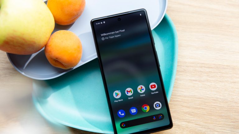 Ein Google Pixel 6a ist an Schalen angelehnt. Das Display ist an und zeigt den App-Drawer.