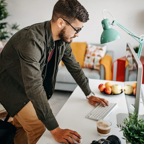 Eine Person st&uuml;tzt die H&auml;nde auf einen Schreibtisch, auf dem ein Mac steht.