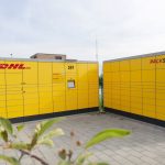 Gelbe Selbstbedienungs-Schlie&szlig;f&auml;cher von DHL auf Asphaltboden.