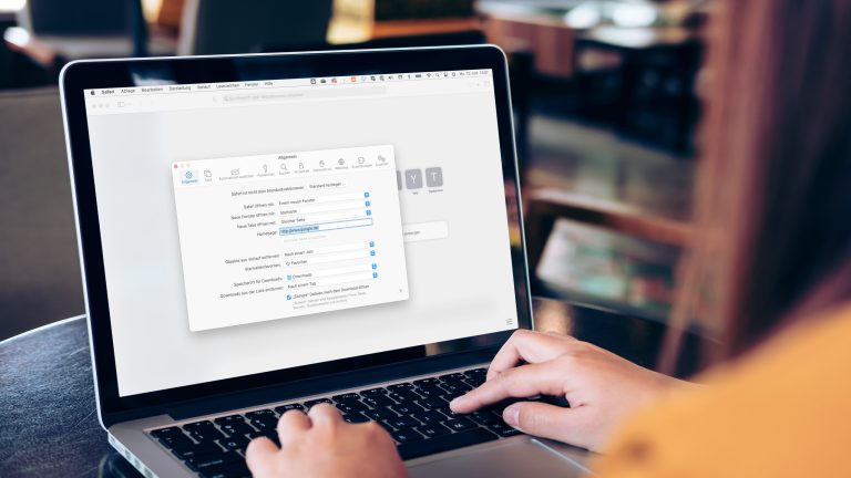 Eine Person tippt auf einem Mac, auf dem die Safari-Einstellungen geöffnet sind.