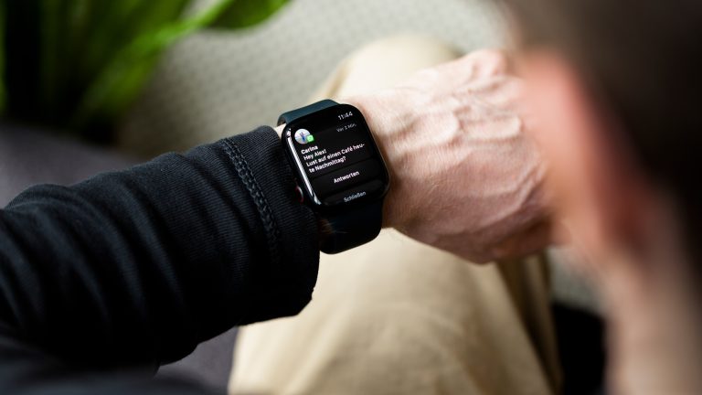 Eine Person schaut auf ihre Apple Watch, auf der gerade eine eingegangene Nachricht angezeigt wird.