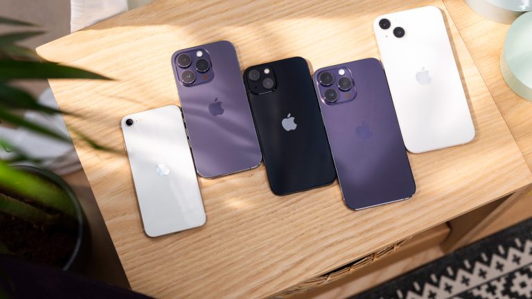 Mehrere iPhone-Modelle liegen auf einem Tisch nebeneinander.