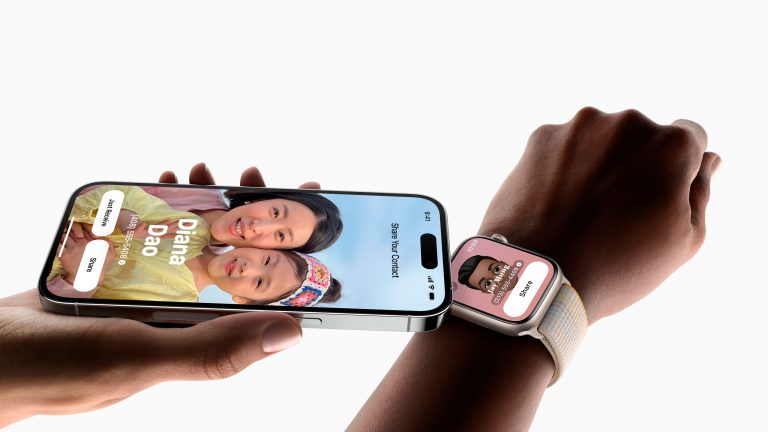 Eine Person hält ein iPhone an die Apple Watch einer anderen Person, um per NameDrop die Kontaktinformationen auszutauschen.