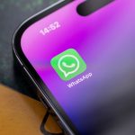 Nahaufnahme eines iPhone 14 Pro, auf dessen Homescreen die WhatsApp-App zu sehen ist.