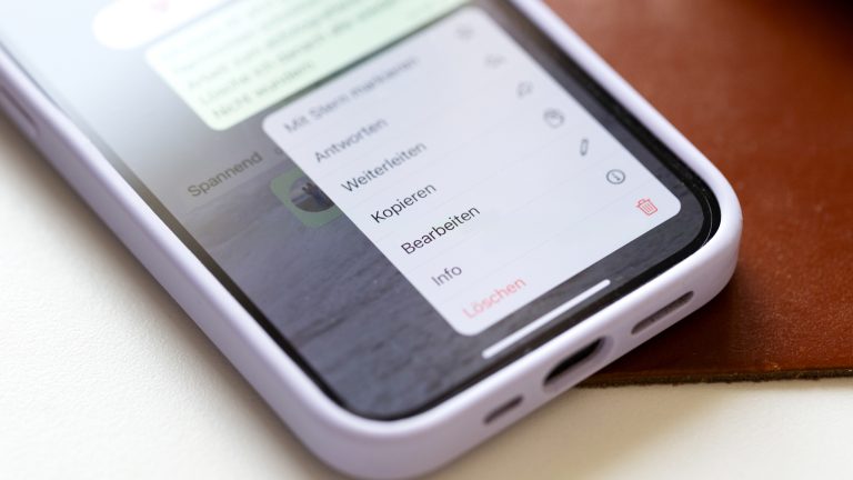 Nahaufnahme eines iPhone 13, auf dem das Kontextmenü einer Nachricht geöffnet ist.