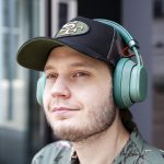 Eine Person hat die Fairbuds XL in Gr&uuml;n auf dem Kopf und schaut in die Ferne.