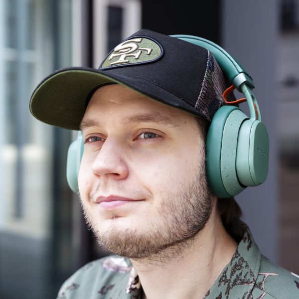Eine Person hat die Fairbuds XL in Gr&uuml;n auf dem Kopf und schaut in die Ferne.