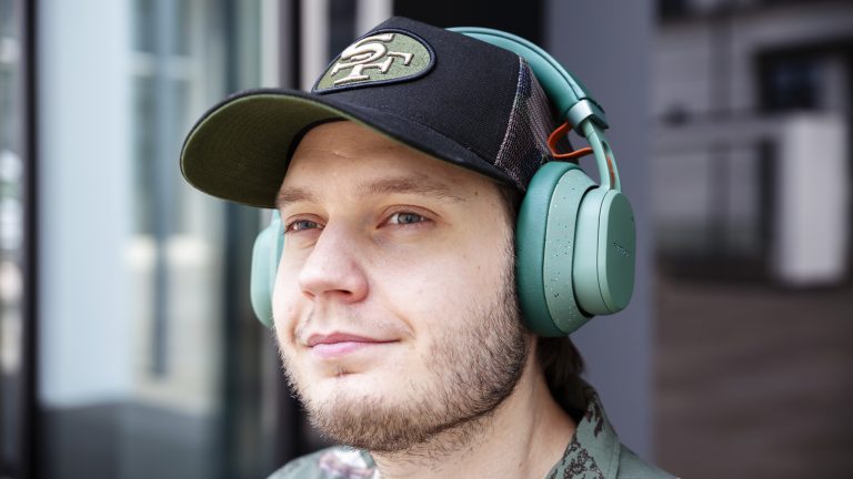 Eine Person hat die Fairbuds XL in Gr&uuml;n auf dem Kopf und schaut in die Ferne.