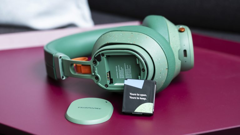 Die Fairbuds XL in Gr&uuml;n mit ausgebautem Akku, der an der Ohrmuschel lehnt.