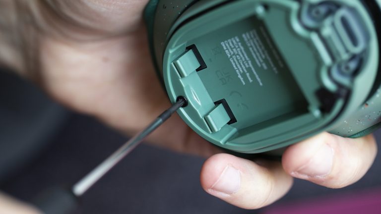 Eine Person schraubt eine kleine Schraube aus einer Ohrmuschel der Fairbuds XL.