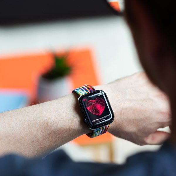 Eine Person trägt eine Apple Watch am Handgelenkt. Auf der ist das EKG zu sehen.