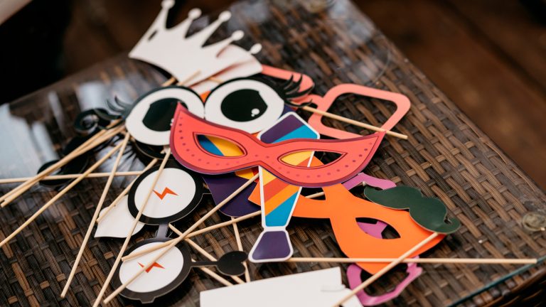 Masken, Brillen und anderweitige Accessoires liegen auf einem Tisch.