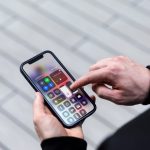 Eine Person tippt auf ein iPhone, auf dem das Kontrollzentrum ge&ouml;ffnet ist.