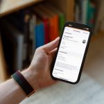 Eine Person hält ein iPhone in der Hand, auf der ein Notfallkontakt zu sehen ist.