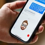 Eine Person h&auml;lt ein iPhone in der Hand, auf der ein Memoji den Gesichtsausdruck der Person nachahmt.