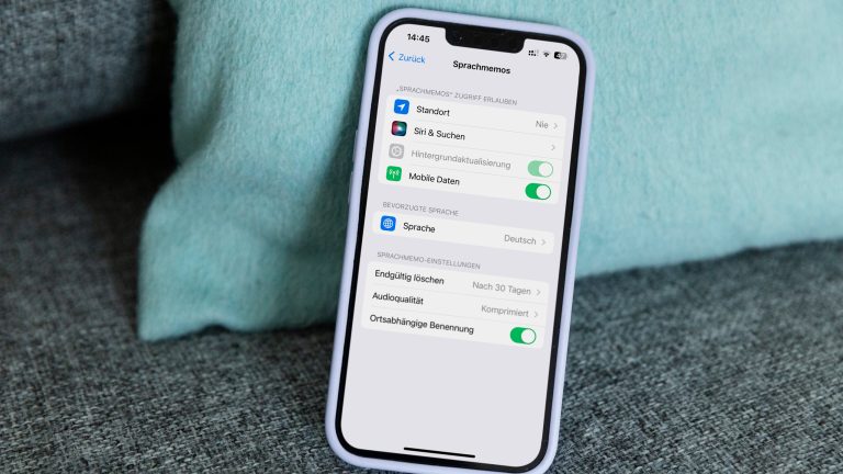 Ein iPhone mit geöffneten Sprachmemo-Einstellungen lehnt an einem türkisenen Kissen.