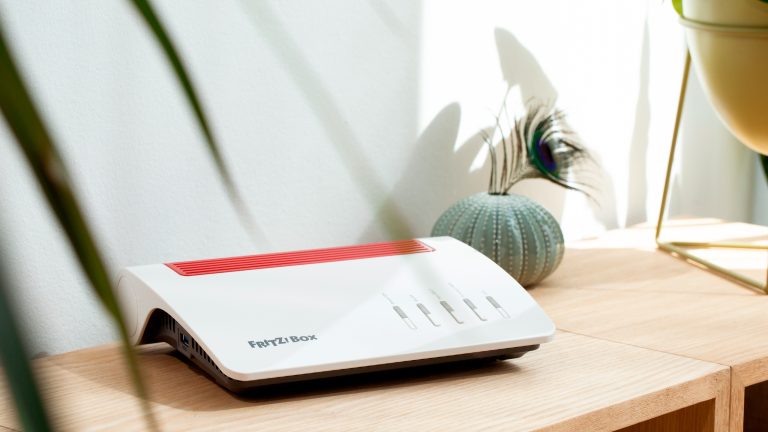 Eine FRITZ!Box 7590 AX steht auf einem Regal.