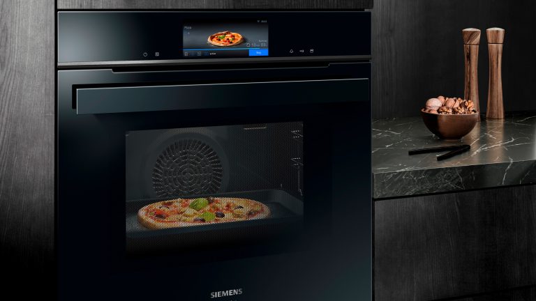 Eine Pizza backt in einem Siemens iQ700 Backofen aus. Auf dem Display ist zu sehen, dass das Gerät das Gericht korrekt erkannt hat.
