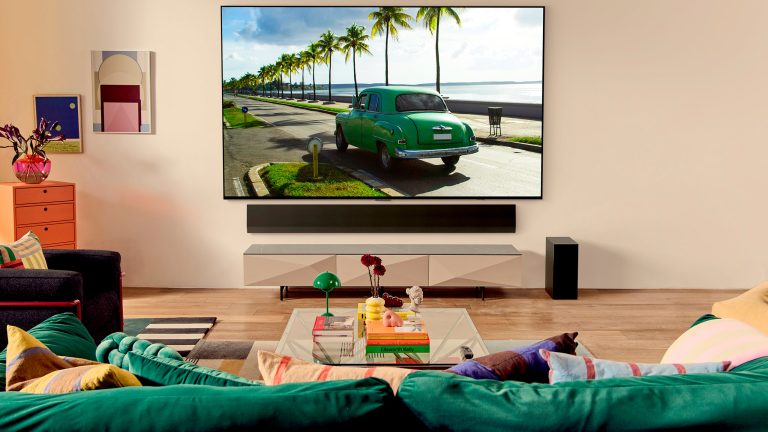 Blick auf einen Fernseher von einer erhöhten Position direkt hinter einem Sofa.