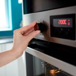 Eine Person dreht an einem Knopf, der an einem Pyrolyse-Backofen angebracht ist.