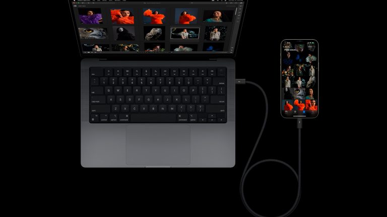Produktbild eines iPhone 15 Pro, das per USB-C-Kabel mit einem MacBook verbunden ist.