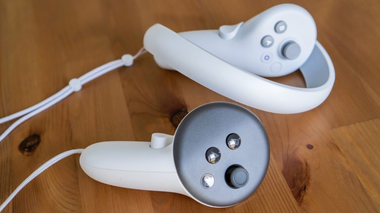 Auf einem Holztisch sind die Controller von Pico 4 (oben) und Quest 3 (unten) zu sehen.