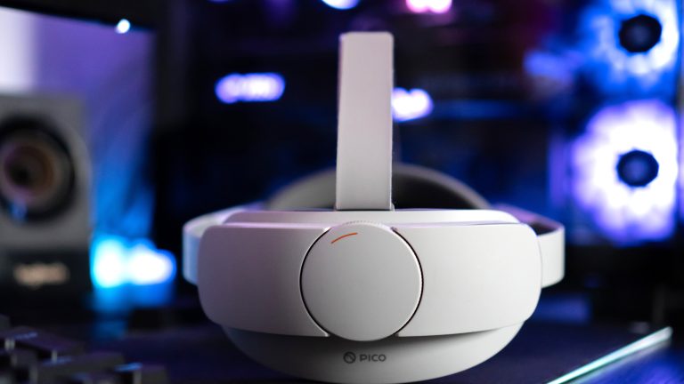 Eine Pico 4 liegt mit der Rückseite zur Kamera vor einem Gaming-PC.