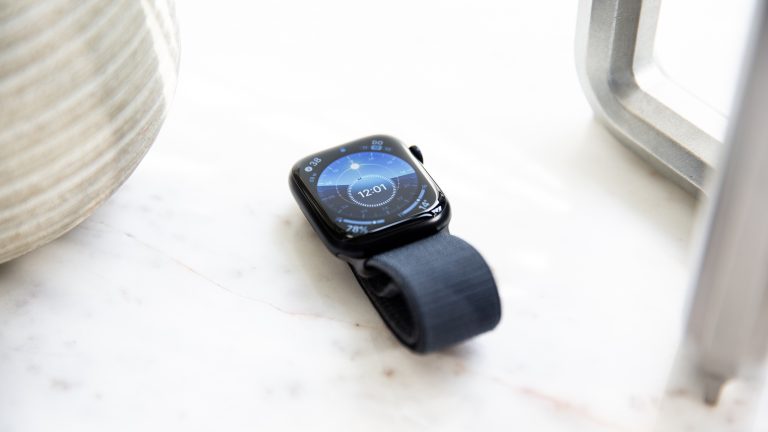 Eine Apple Watch Series 9 liegt neben einem Kerzenständer auf einer Marmor-Oberfläche.