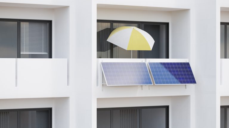 Zwei Photovoltaikanlagen als Teil eines Balkonkraftwerks an einem weißen Haus.