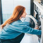 Eine Person bef&uuml;llt eine Waschmaschine.