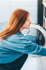 Eine Person befüllt eine Waschmaschine.