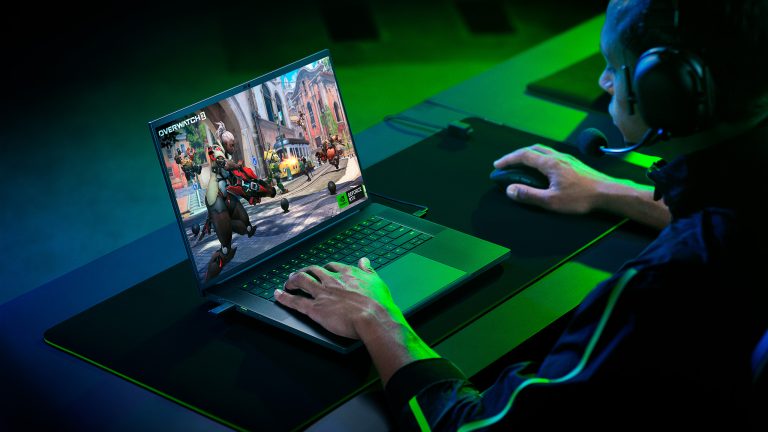 Eine Person sitzt vor einem Razer Blade 16 und spielt Overwatch 2.
