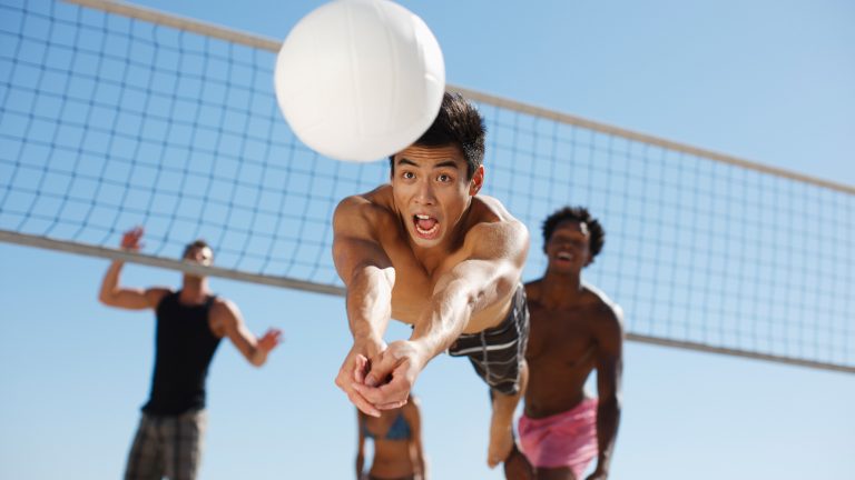 Eine Person ist gerade dabei einen Volleyball per Dive zu spielen.