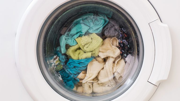 Blick in die prall gefüllte Trommel einer Waschmaschine.