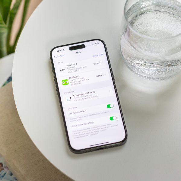 Ein iPhone liegt auf einem Tisch, darauf zu sehen sind abgeschlossene Abos.