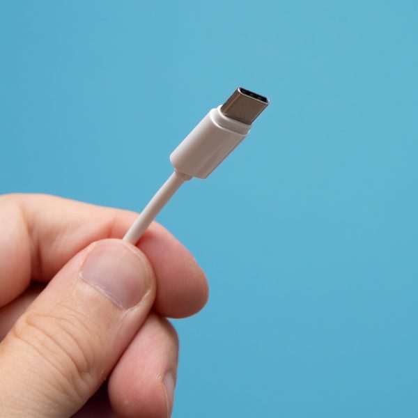 Eine Person h&auml;lt ein Kabel mit einer USB-C-Steckverbindung in die Kamera.
