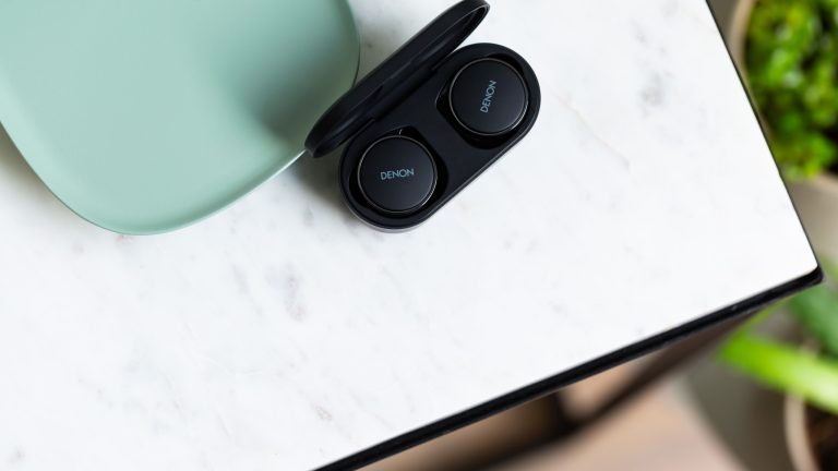 Blick auf die Denon PerL Pro, die in ihrem Ladecase liegen.