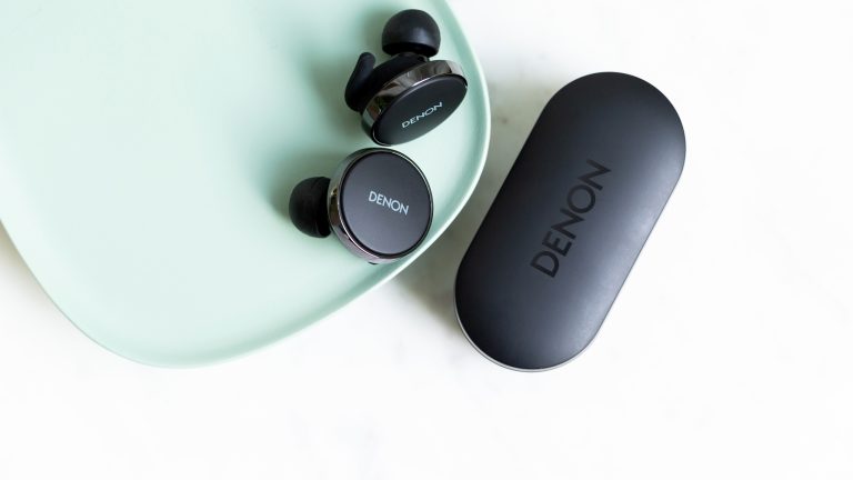 Nahaufnahme der PerL Pro, die mitsamt Ladecase auf einem Tisch liegen.