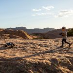Ein Kind steuert ein ferngesteuertes Auto &uuml;ber sandige Pisten.