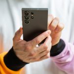 Eine Person h&auml;lt ein Smartphone in der Hand.