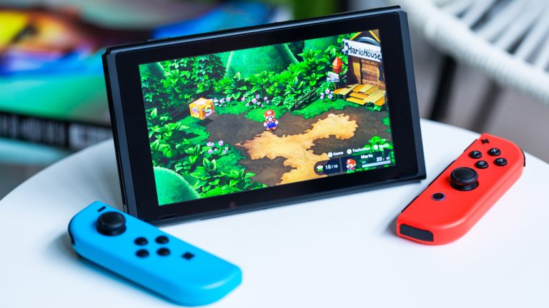 Eine Nintendo Switch mit abgenommenden Joy-Cons steht auf einem Tisch.