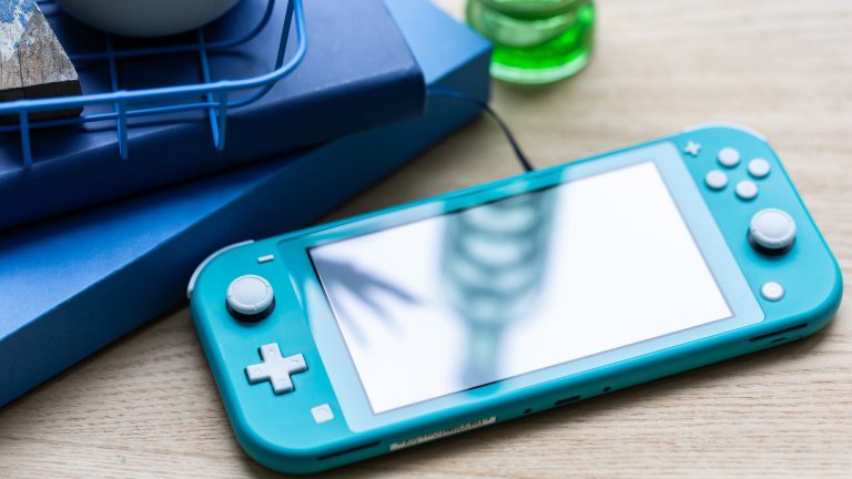 Eine Nintendo Switch Lite in Blau liegt auf einem Tisch.