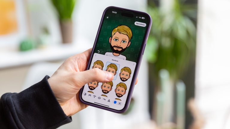 Eine Person h&auml;lt ein iPhone in der Hand, auf der die Bitmoji-Erstellung zu sehen ist.
