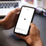 Eine Person h&auml;lt ein Smartphone in der Hand. Darauf ist die ChatGPT-App ge&ouml;ffnet.