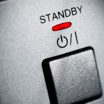 Der Einschaltknopf eines Elektroger&auml;ts mit dem Schriftzug Standby und einer rot leuchtenden Anzeige dazu.