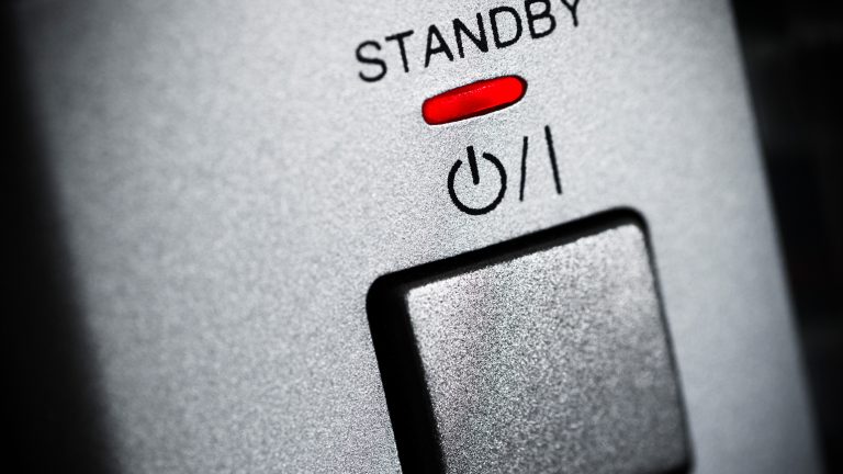 Der Einschaltknopf eines Elektrogeräts mit dem Schriftzug Standby und einer rot leuchtenden Anzeige dazu.