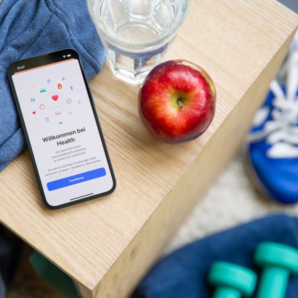 Auf einem Holztisch liegt ein iPhone. Darauf ist die Health App ge&ouml;ffnet.