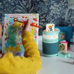 Ein Kind malt auf einer Leinwand. Daneben steht der Kinder-Lautsprecher Galakto samt einiger Audio-Tokens.