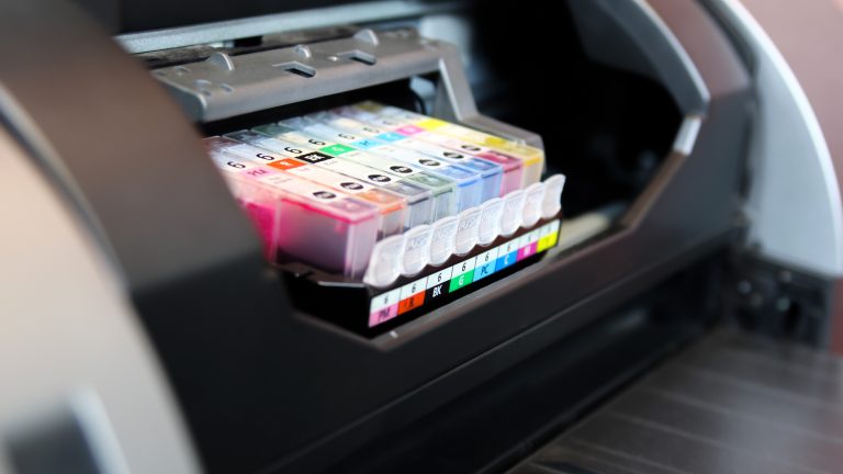 In einem geöffneten Tintenstrahldrucker ist der Schlitten zu sehen, in dem die Tintenpatronen eingesetzt sind.
