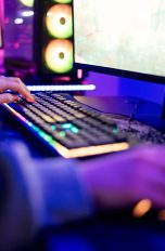 Eine Person sitzt vor einem Gaming-PC und spielt etwas. Schütze dein Konto, ehe du dich in das nächste Match schmeißt. Das lohnt sich nämlich auch im Spiel für dich.